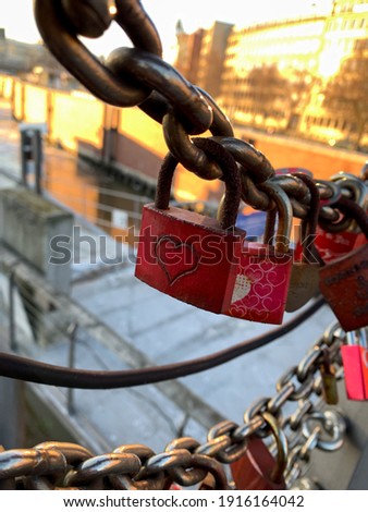 Red vintage Lovelock with heart symbol on metal chain close up on Harbor bridge for lovers