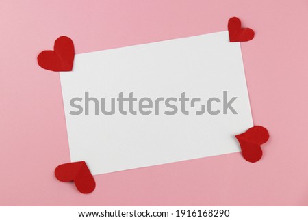 A blank white card for filling text and with handmade heart-shaped paper. Valentine's Day Concepts.