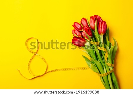 Banner with lush bouquet of red tulips and number eight on a yellow background with copy space, empty text place. International woman day March 8. Mother Day. Gift certificate. Mockup. Greeting card.