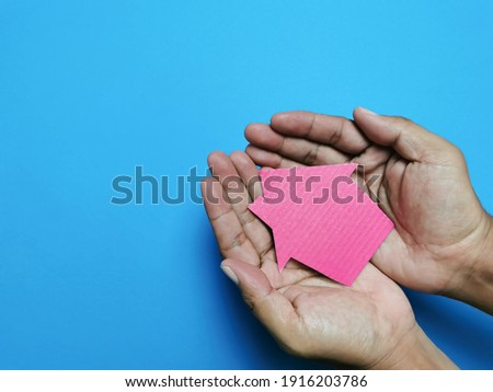 House cupboard on hands palm isolated on blue background. Property concept.Copy space for text.