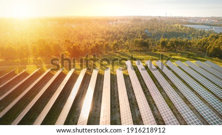 Aerial view of ecology solar power station panels farm on sunset or sunrise. Rows of modern photovoltaic solar panels. Renewable green energy Royalty-Free Stock Photo #1916218912