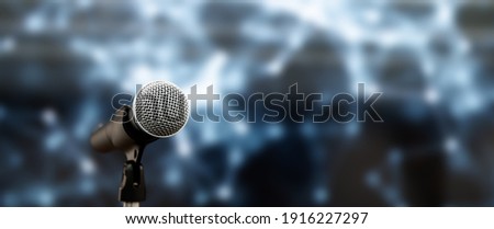 Public speaking backgrounds, Close-up the microphone on stand for speaker speech presentation stage performance with blur and bokeh light background. Royalty-Free Stock Photo #1916227297