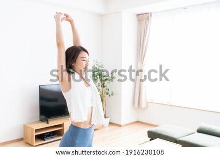 Beautiful young asian woman exercising in the room Royalty-Free Stock Photo #1916230108