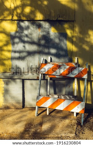 colorful hazard signs leaning against an old building