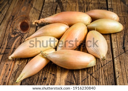 Fresh Shallot onions Bulbs on kitchen table. Wooden background. Top view