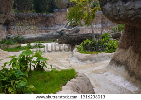 This is a landscape picture of a small creek, surrounded by rocks and grass.