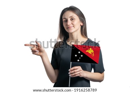 Happy young white woman holding flag Papua New Guinea and points to the left isolated on a white background.