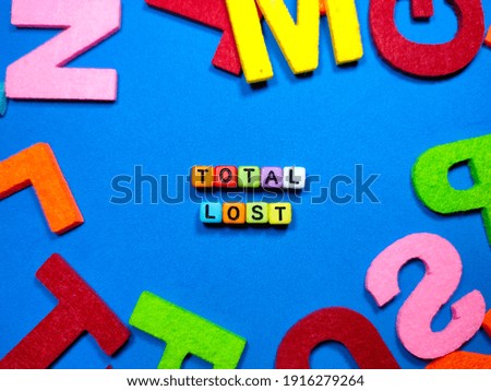 Selective focus.Colorful dice with word TOTAL LOST on blue background.Transportation concept.Shot were noise and film grain.