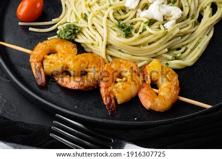 Seafood spaghetti pesto ready to eat set, on plate, on black background