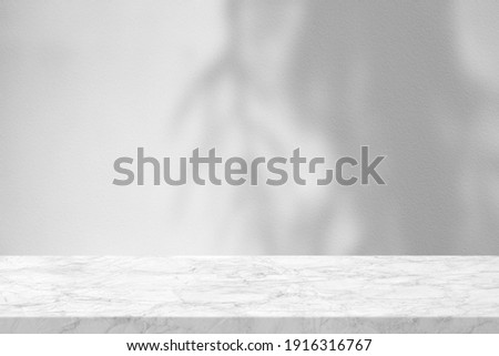 Marble Table with Leaves Shadow on Stucco Wall Texture Background, Suitable for Product Presentation Backdrop, Display, and Mock up. Royalty-Free Stock Photo #1916316767