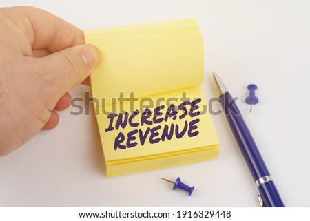 Business and finance concept. The man is leafing through the stickers, the sheet says - INCREASE REVENUE