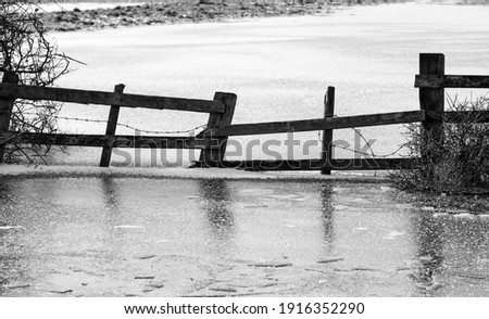 Old farm fence trapped in ice