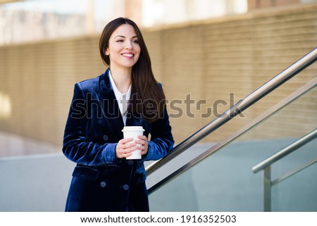 Business woman wearing blue suit taking a coffee break outside her office. Lifestyle concept.