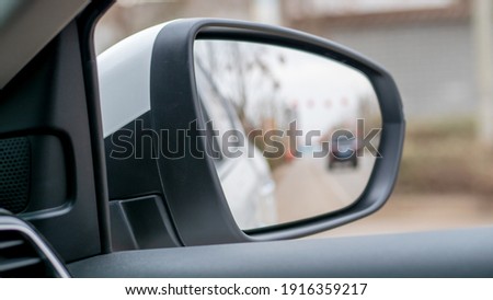 The rearview mirror on the right side of the car and the reflected landscape inside Royalty-Free Stock Photo #1916359217