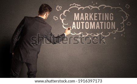 businessman drawing a cloud with MARKETING AUTOMATION inscription inside, modern business concept