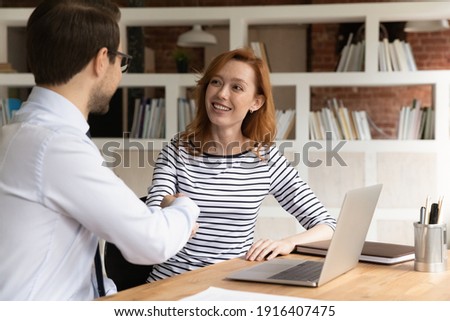 Smiling Caucasian diverse employees shake hands get acquainted greeting at meeting in office. Happy businesspeople handshake close deal make agreement at negotiation. Partnership concept.