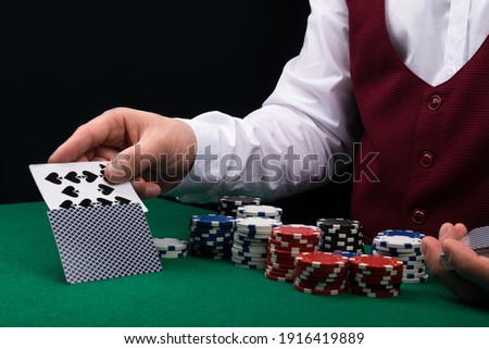 the croupier at the green poker table opens a combination of cards, close-up
