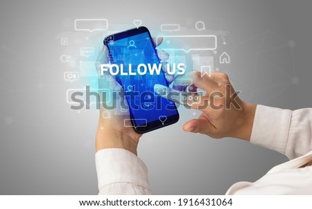 Female hand typing on smartphone with FOLLOW US inscription, social media concept