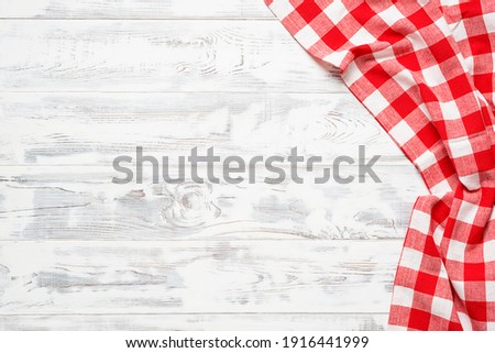 White wooden table covered with red tablecloth. View from top. Empty tablecloth for product montage. Free space for your text Royalty-Free Stock Photo #1916441999
