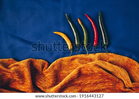 Summer forest landscape made of red, green and yellow chilli paprika blue background. Minimal nature concept. Flat lay.