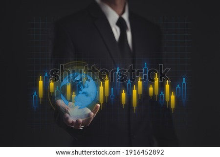 Businessman in black suit showing world map and candlestick chart by hologram effect.