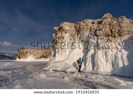 A tourist takes pictures of the icy cliffs of Oltrek Island