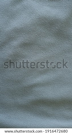 smoky gray material with short pile as a monochrome textured fabric background full frame with slight subtle folds on a fleecy surface, monochrome dark textile for making sportswear