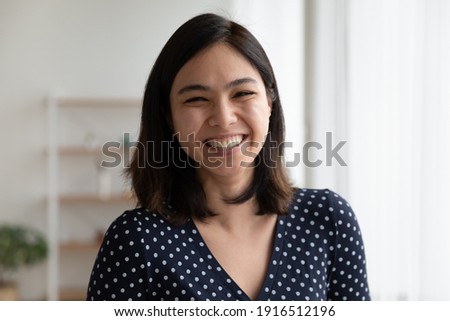 Portrait of happy overjoyed pretty asian woman look at camera with sincere laughter. Laughing excited female customer leave positive video feedback to ordered goods received service on company website Royalty-Free Stock Photo #1916512196