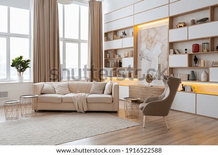 interior design spacious bright studio apartment in Scandinavian style and warm pastel white and beige colors. trendy furniture in the living area and modern details in the kitchen area. Royalty-Free Stock Photo #1916522588