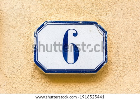house number six, sixth ( 6 ) on a roughcast wall Royalty-Free Stock Photo #1916525441