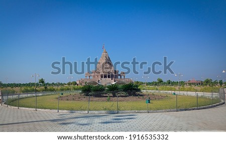Beautiful image of Khodaldham Kagvad  temple, Rajkot, Gujarat, India with blue sky and fluffy clouds in the background Royalty-Free Stock Photo #1916535332