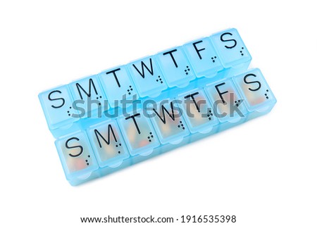 Daily portion of vitamins, drug medicines, tablets, dietary supplements in pill organizer or plactic pill box. A weekly container of tablets, vitamins. Nutritional supplements