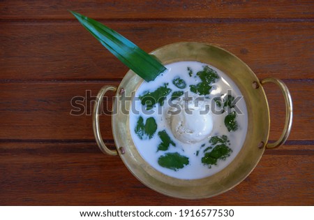traditional Thai dessert made from tapioca flour and coconut milk on top with milk ice cream served in vintage brass pan  Royalty-Free Stock Photo #1916577530