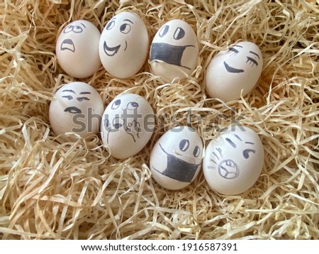 many white chicken eggs with funny faces lie in nest of straw on white background. painted eggs with emotions: with eyes and in mask, sad and surprise. preparation for Easter. creativity