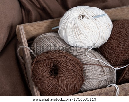 Woden box with yarn balls and a hook inside. Crochet knitting.  Royalty-Free Stock Photo #1916595113