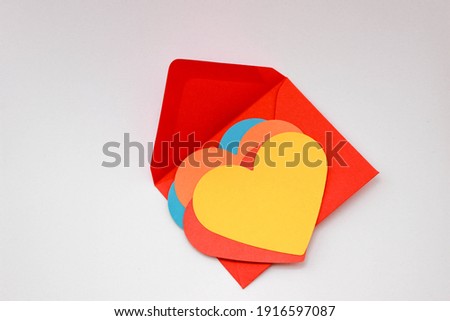 Colorful heart shaped papers on colorful envelope, top view. 
