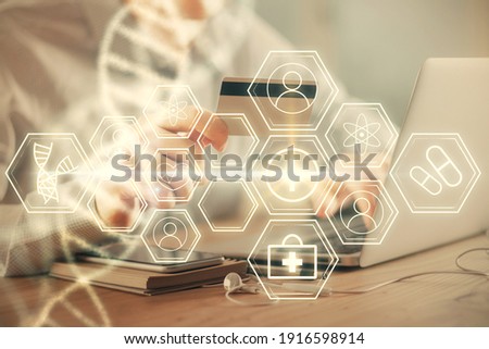 Double exposure of man hands holding a credit card and DNA drawing. On-line Education and E-commerce concept.