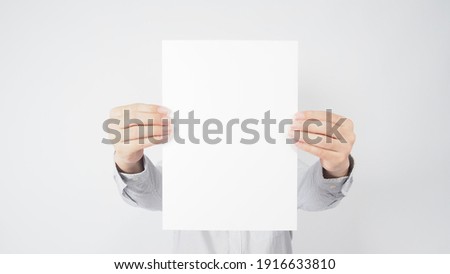 blank empty paper in man hand and wear shirt on white background.asian people