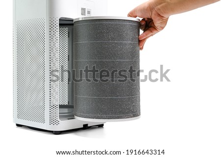 Man hold a old Filter of  the air purifier check with change filter in side air purifier for dust removal efficiency on white background