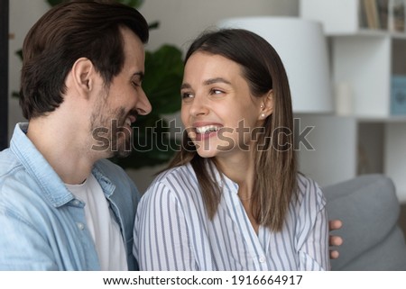 The one who always understand. Loving young spouses spend time together hug on couch look in eyes talk listen to each other. Millennial husband wife rest at home enjoy pleasant romantic conversation Royalty-Free Stock Photo #1916664917