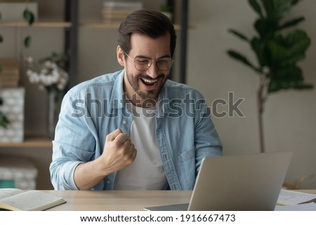 Stroke of luck. Excited young man remote worker get email from ceo about reward for performance of professional skills recognition promotion. Happy guy student sit by laptop celebrate good exam result Royalty-Free Stock Photo #1916667473
