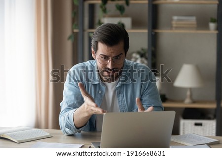 It makes no sense. Shocked young guy software developer look at laptop screen unable to find fix error in program code. Annoyed man enterpreneur get rejection of profitable offer from business partner Royalty-Free Stock Photo #1916668631
