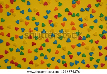 Colorful heart shape sweet candy on bright yellow background. Happy birthday greeting card. Holiday background. Sweet candy concept. Love. Minimal concept.                                           