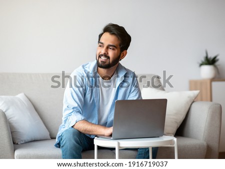 Portrait Of Pensive Arab Freelancer Guy Working With Laptop Computer At Home And Looking Aside, Thinking Thinking About Business Ideas, Thoughtful Eastern Guy Enjoying Remote Work, Copy Space Royalty-Free Stock Photo #1916719037