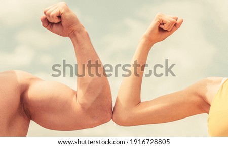 Muscular arm vs weak hand. Vs, fight hard. Competition, strength comparison. Rivalry concept. Hand, man arm fist Close-up. Rivalry, vs, challenge, strength comparison. Sporty man and woman. Royalty-Free Stock Photo #1916728805