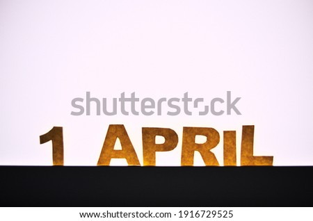 Image caption April 1 of yellow paper letters through which the light of an LED lamp passes. High quality photo