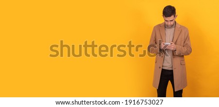 young man with mobile phone on color background