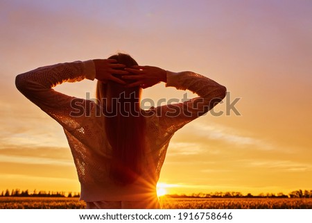 silhouette of happy young woman on sunset , outdoor girl in a field