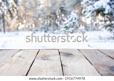 Beautiful winter scene. blurred background of snowy christmas nature background, Wood table top on shiny bokeh. For product display Christmas time mock up
