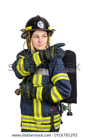 Young caucasian woman in uniform of fireman posing in profile with Air Tank on her back and pointing away isolated on white background